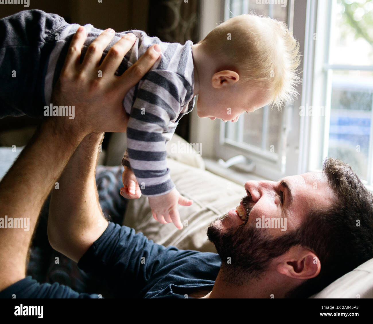 A father holds up his baby boy. Stock Photo