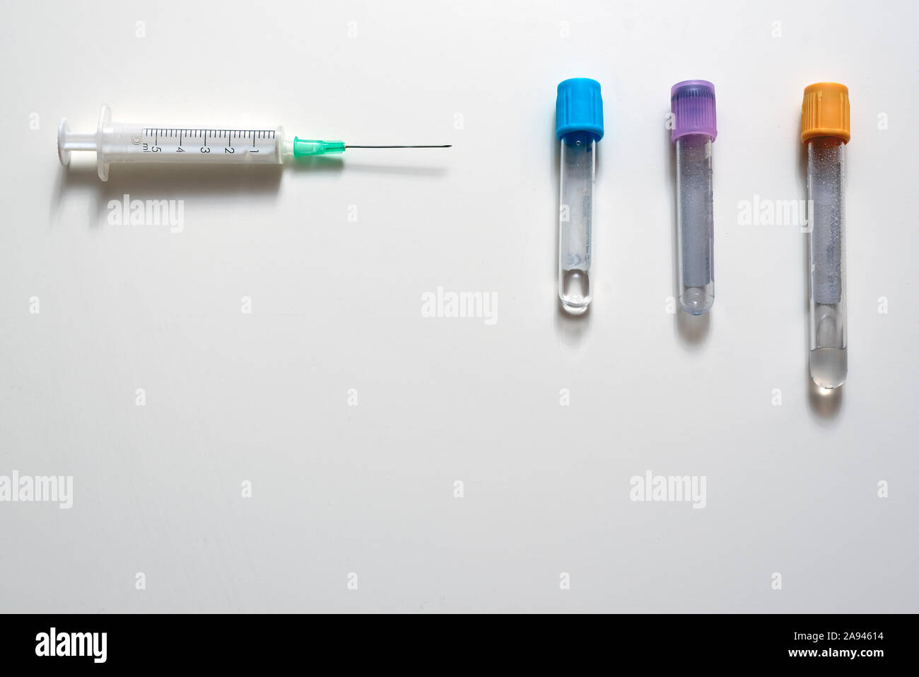 Syringe with needle and three jars to take blood samples for analysis Stock Photo