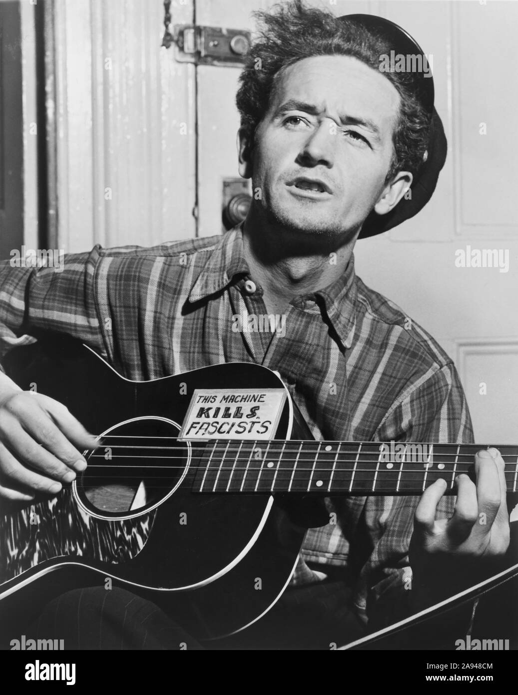 Woody Guthrie (1912-1967), Half-Length Portrait Playing Guitar, Photograph by Al Aumuller, World Telegram, 1943 Stock Photo