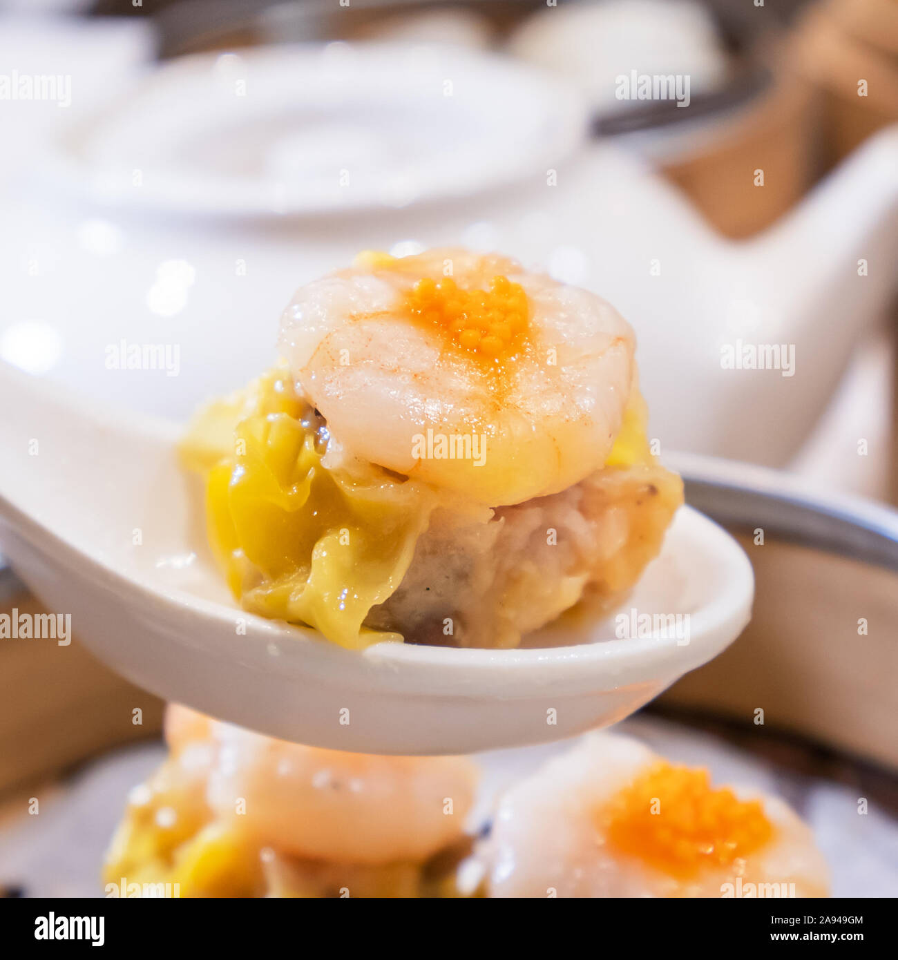 Siu Mai, one of Dim Sum yum cha, pork and shrimp steamed dumplings on restaurant house white background table for breakfast, lifestyle, close up. Stock Photo
