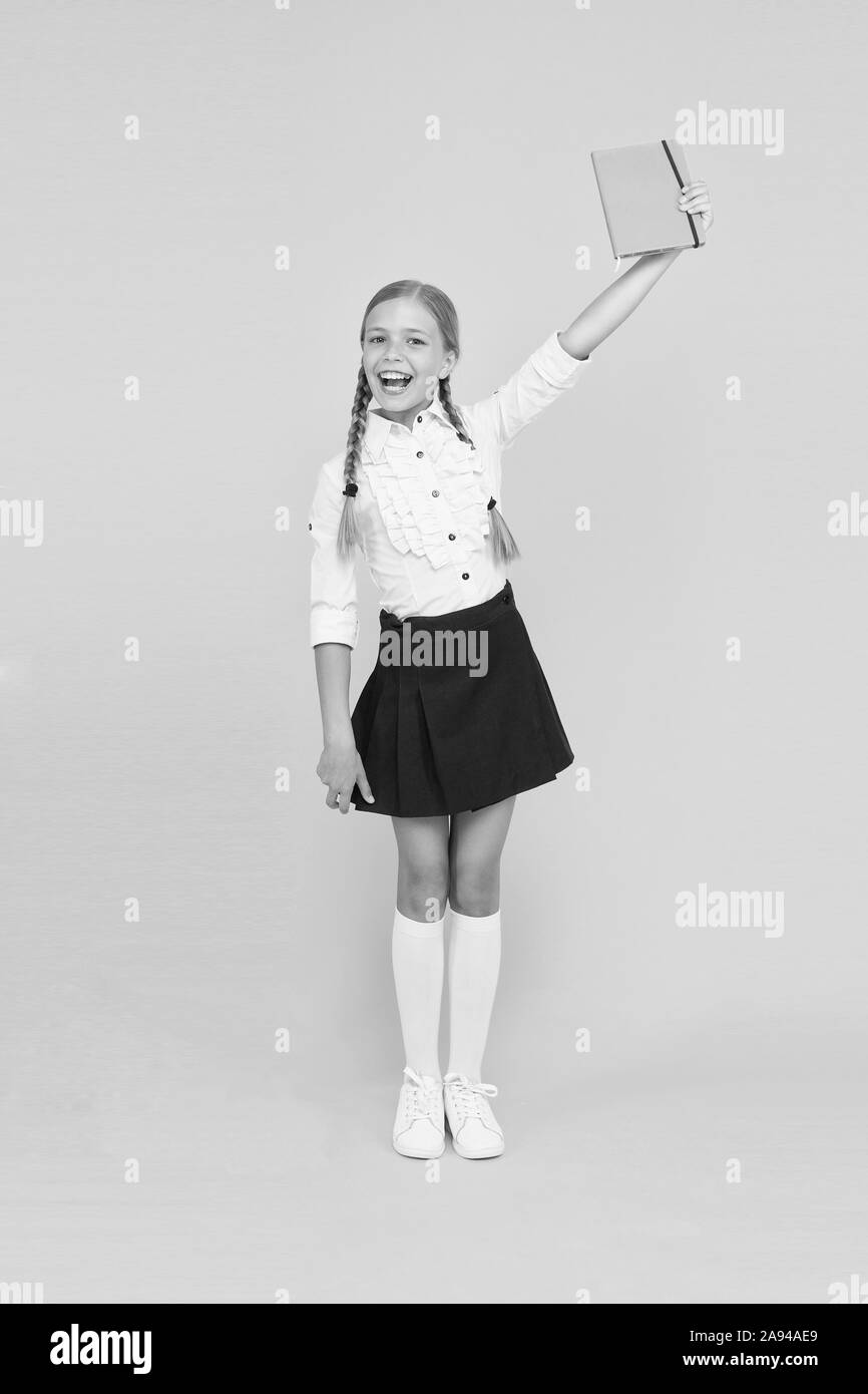 Study literature. Towards knowledge. Learn following rules. Welcome back to school. Inspirational quotes motivate kids for academic year ahead. School girl formal uniform hold book. School lesson. Stock Photo
