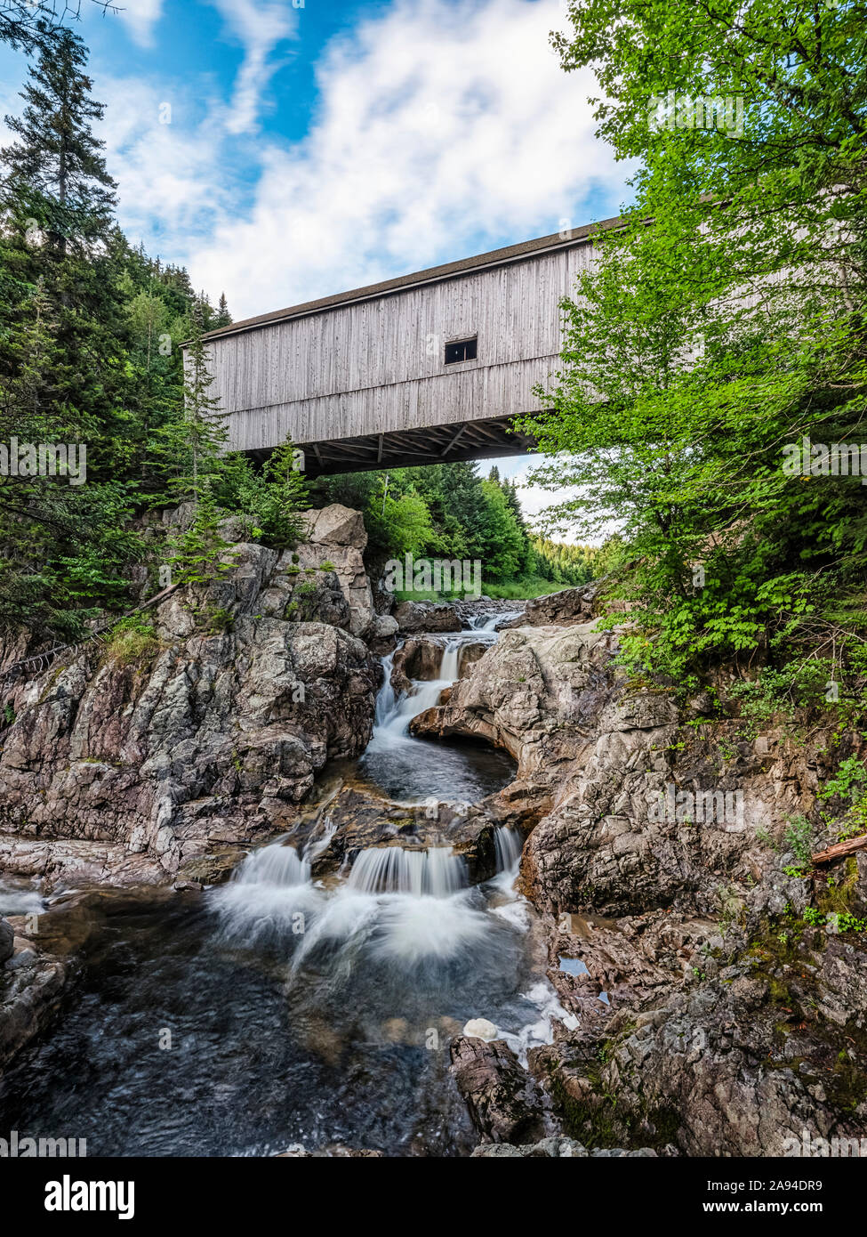 Historic covered bridge over creek and waterfall; Saint John, New Brunswick, Canada Stock Photo