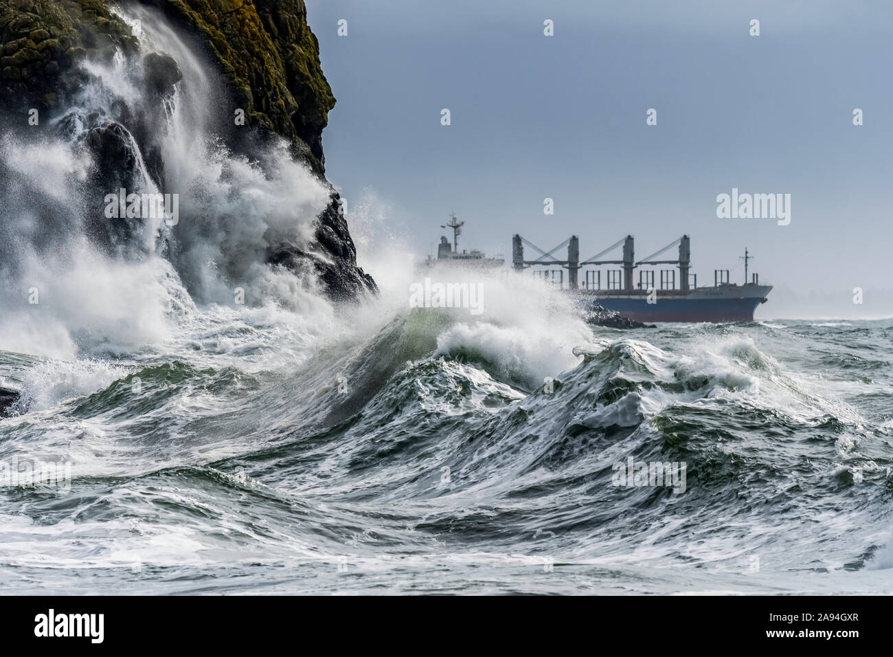 A bulk carrier ship passes Cape Disappointment at rhe mouth of the Columbia River; Ilwaco, Washington, United States of America Stock Photo