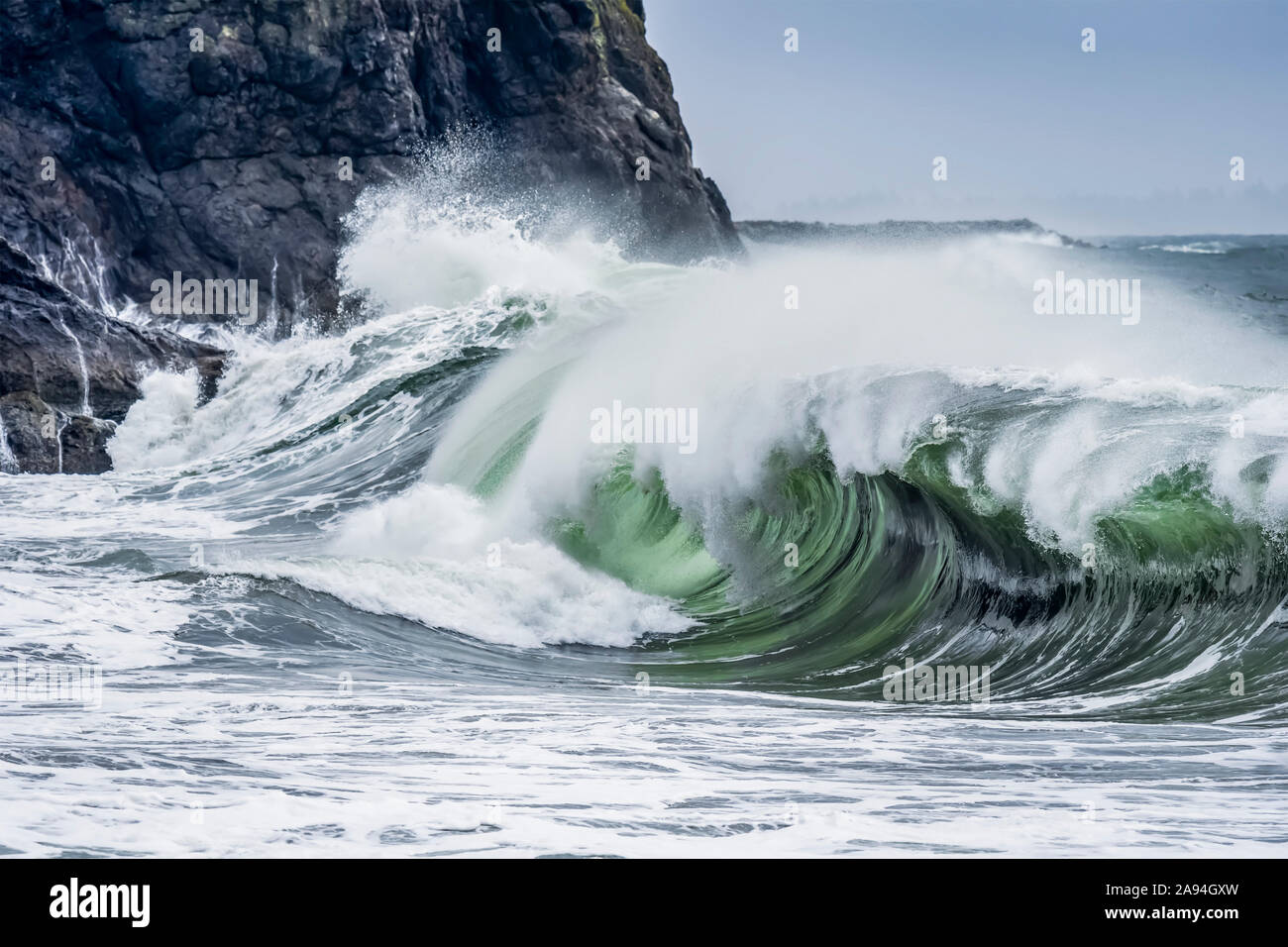 A wave shows its dark interior at Cape Disappointment on the Washington Coast; Ilwaco, Washington, United States of America Stock Photo
