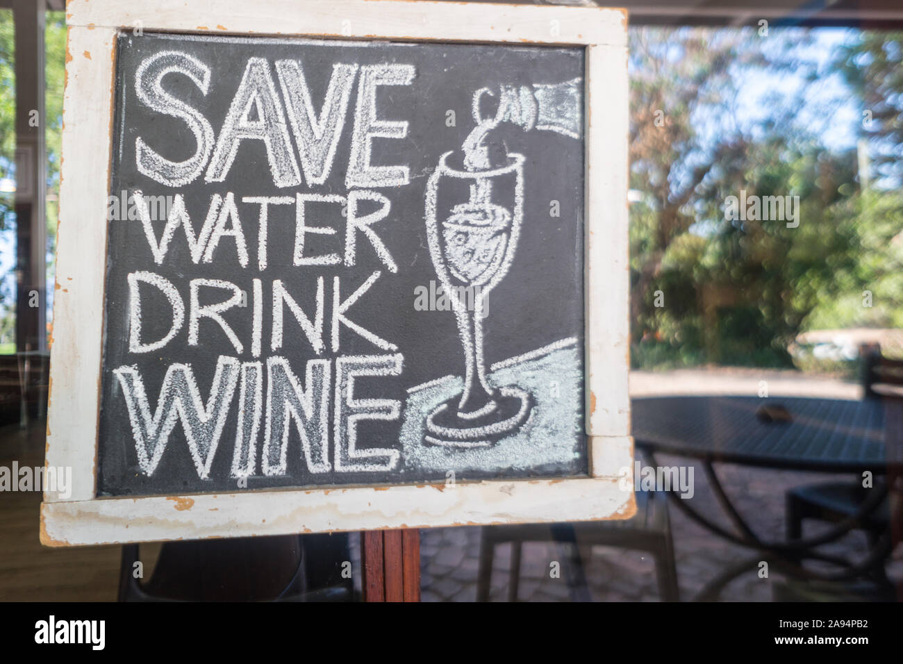 humorous, funny, quirky sayings, anecdotes, messages written on a chalkboard in white chalk about wine at a wine estate concept wine lifestyle Stock Photo