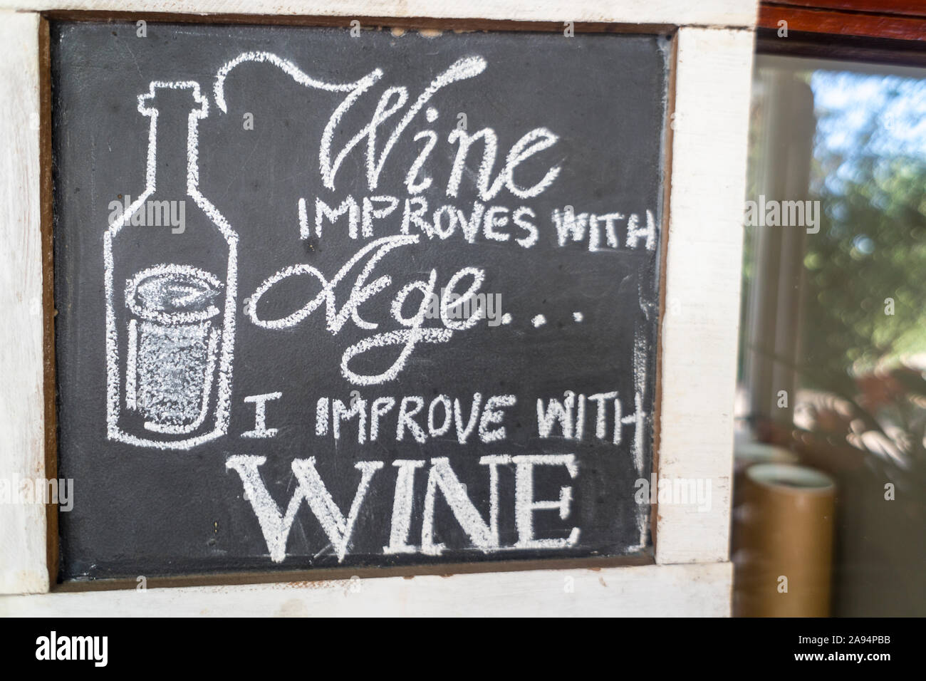 humorous, funny, quirky sayings, anecdotes, messages written on a chalkboard in white chalk about wine at a wine estate concept wine lifestyle Stock Photo
