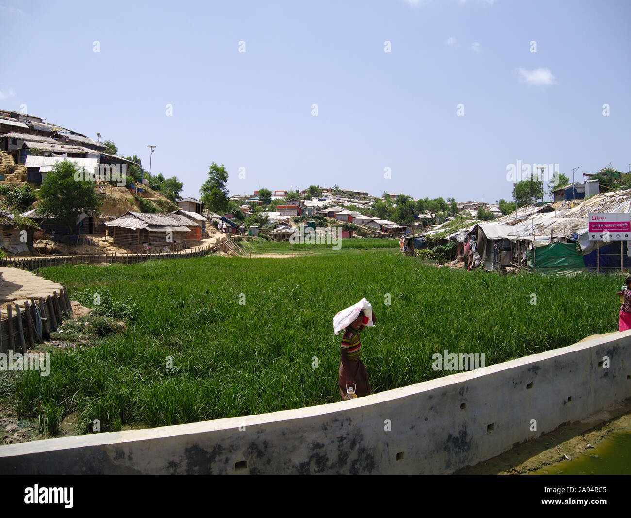 A boy carries food from a distribution in the Rohingya Refugee Mega Camp Stock Photo
