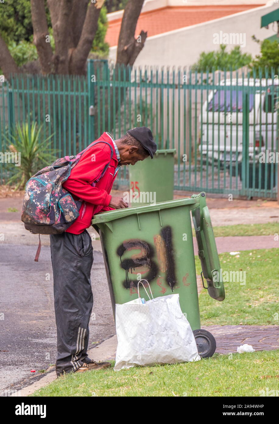 Alberton, South Africa unidentified old black man searches through a