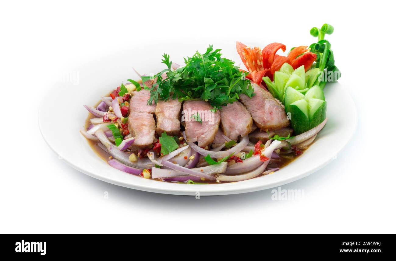 Spicy Grilled Pork Slices Salad in Pickled Fish Sauce and onion slice Thai Food Hot Spicy dish decorate with carved cucumber,tomato vegetables side vi Stock Photo