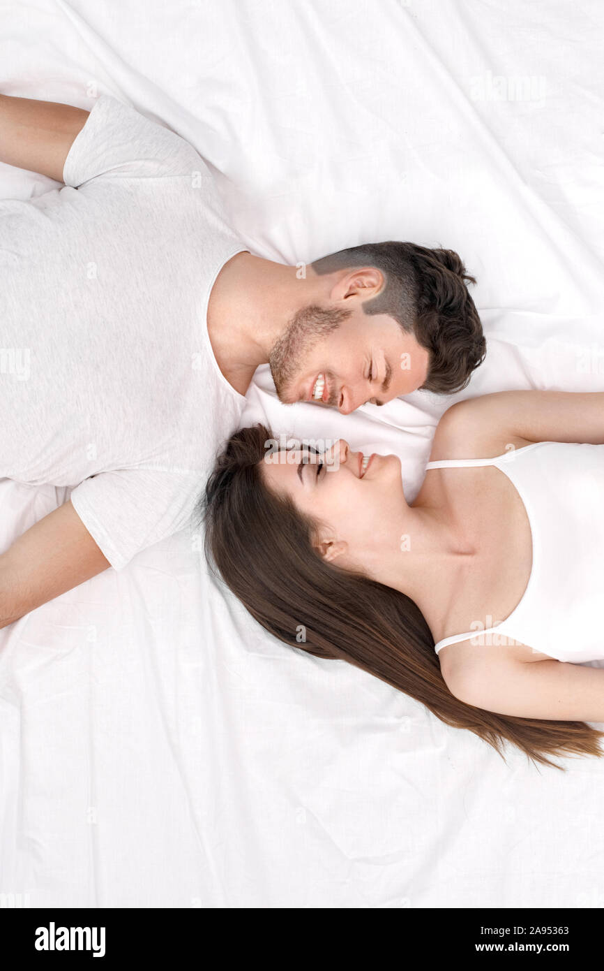 Bedtime Young Couple Lying On Bed Top View Isolated On White Looking bedtime-young-couple-lying-on-bed-top-view-isolated-on-white-looking