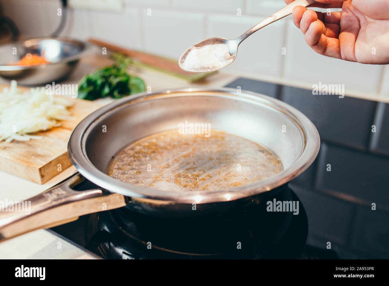 Kitchen life hacking - how to clean the pan from carbon deposits - a  spoonful of baking soda in boiling water Stock Photo - Alamy