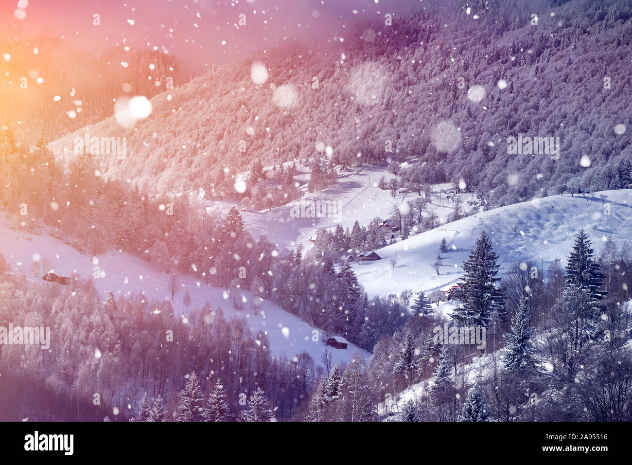 Magic Christmas concept with falling snow over beautiful winter landscape in the sunset. Stock Photo