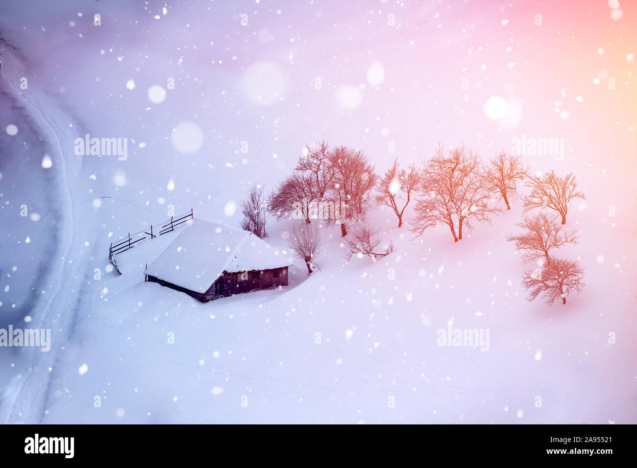 Magic Christmas concept with falling snow over beautiful winter landscape in the sunset. Stock Photo