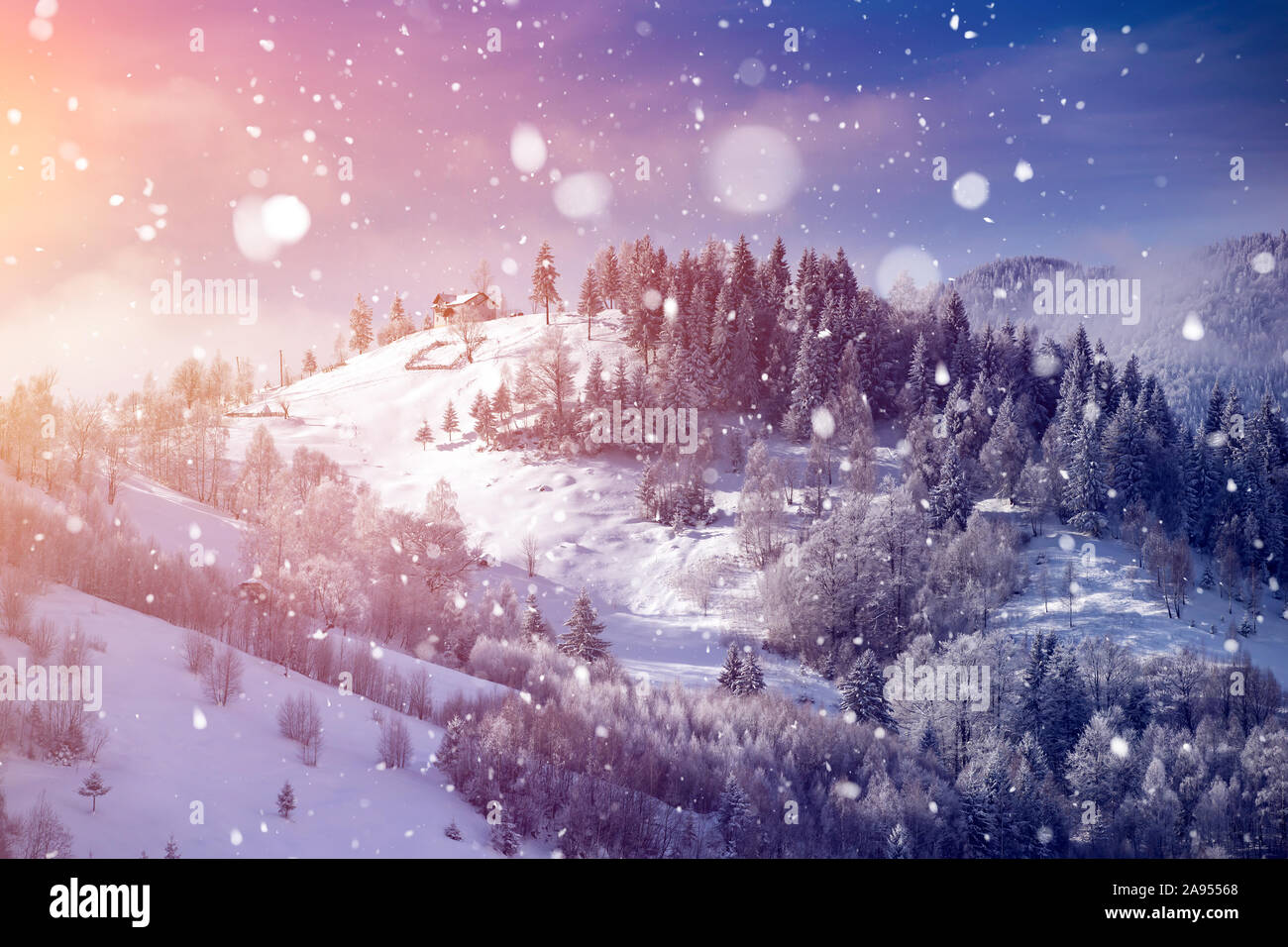 Magic Christmas concept with falling snow over beautiful winter landscape in the sunset. Stock Photo