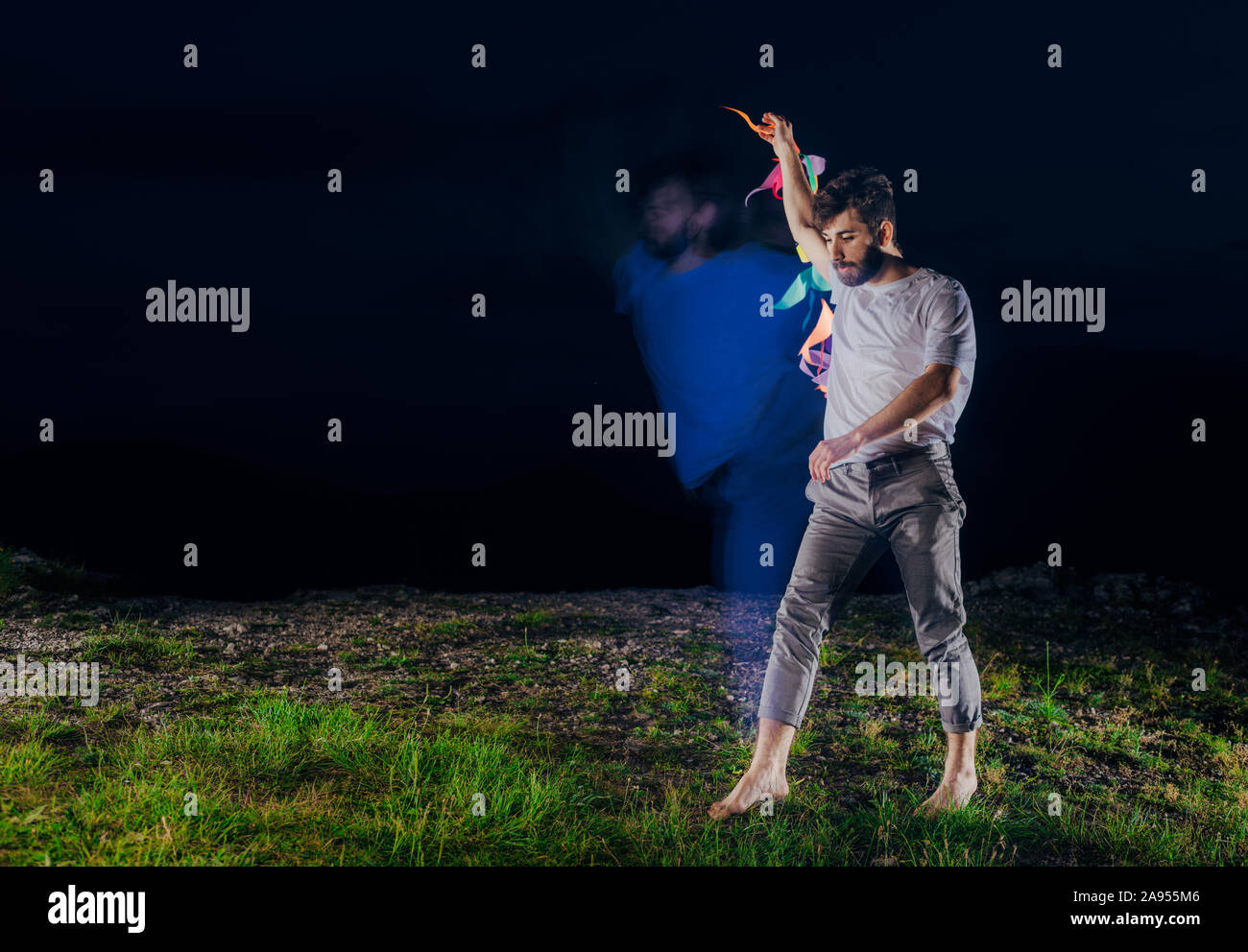 Handsome man dancer while dancing to the rhythm of the dance on mountain lawn Stock Photo