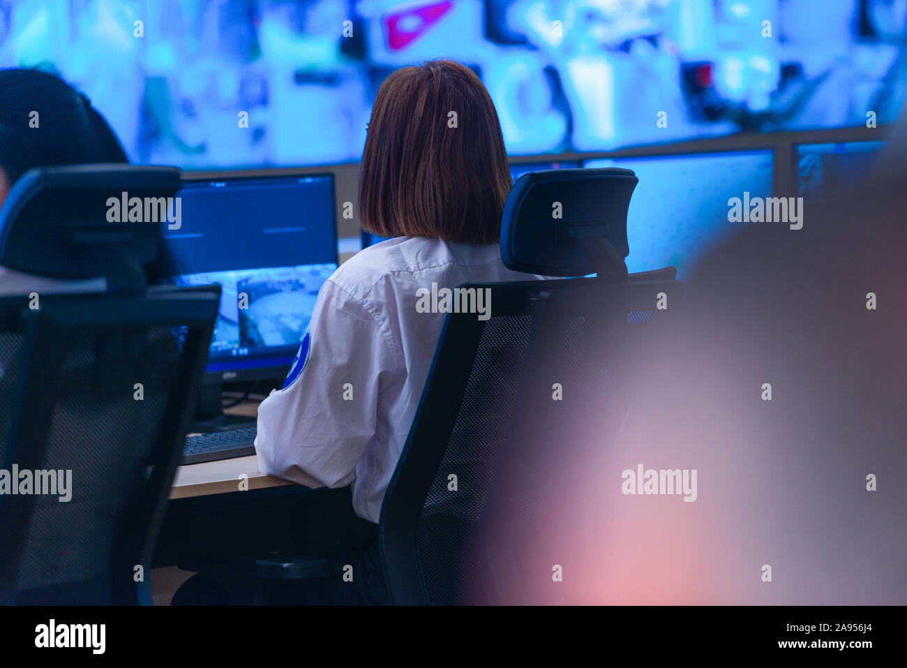 In the System Control Room, Technical Operator Works at His Workstation with Multiple Displays, Security guard working on multiple monitors. Stock Photo