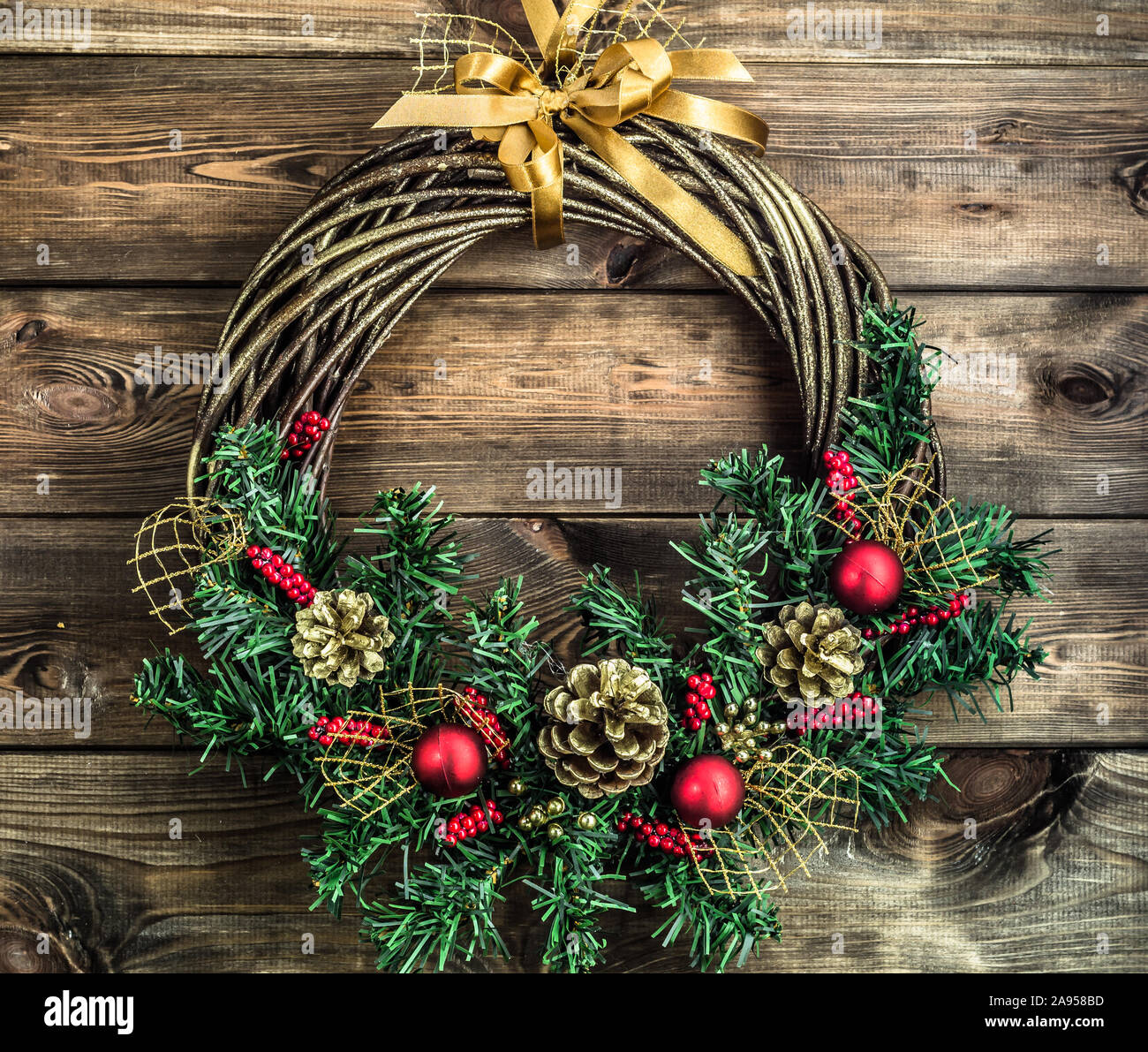 Christmas wreath hanging on wooden door. Decoration with pine cone and ...