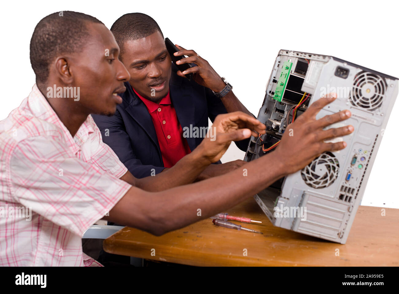 two technicians sitting at the desk working together on a computer Stock Photo