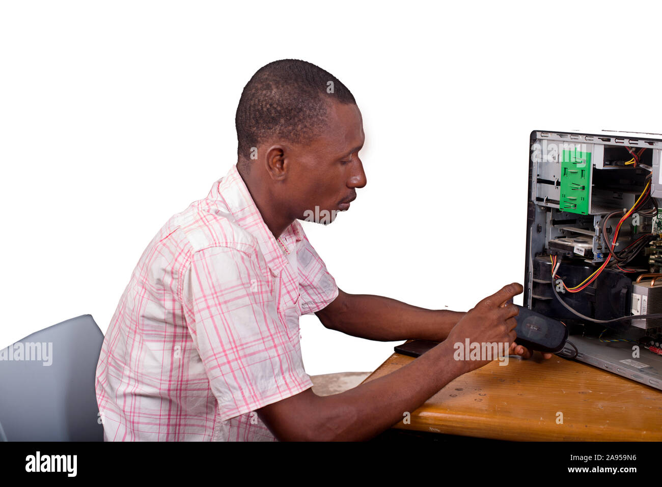 Young technician working on broken computer in his office Stock Photo