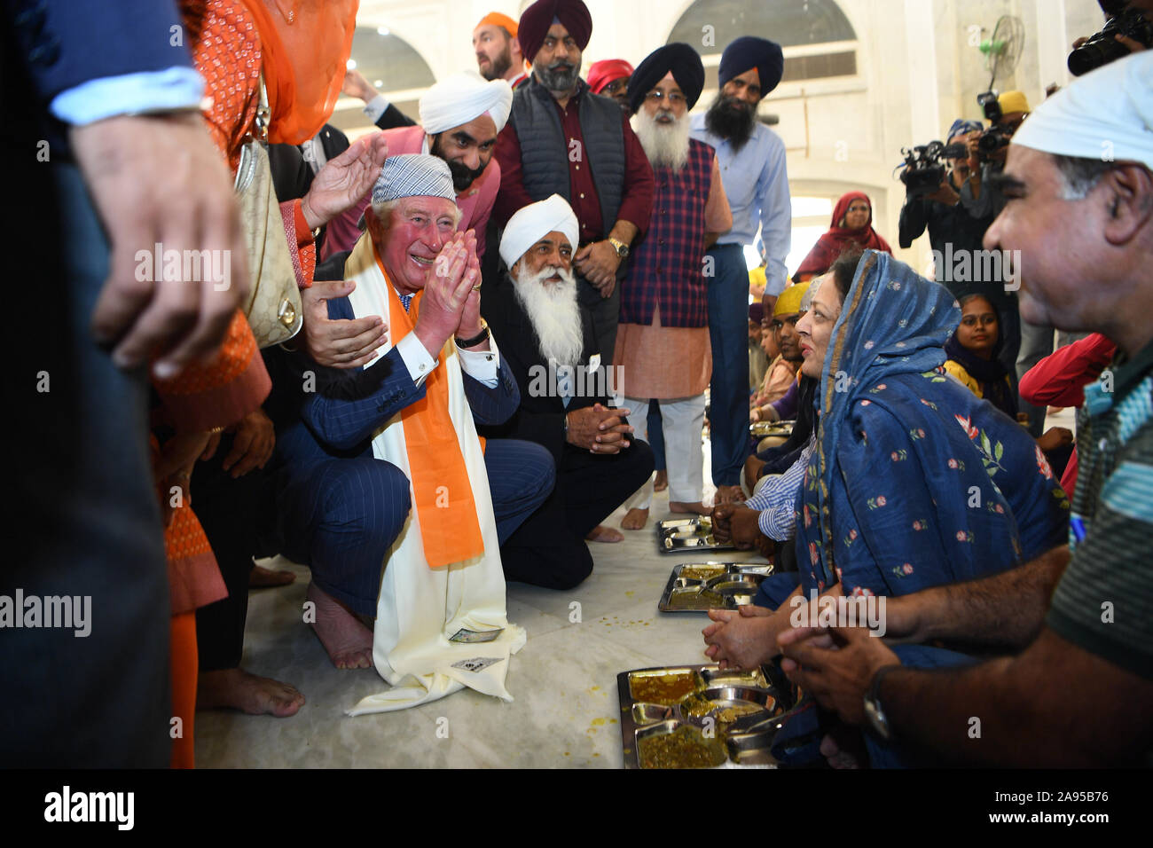 The Prince of Wales speaks with worshippers as he visits the Bangla Sahib Gurdwara Sikh Temple, New Delhi, to celebrate the 550th anniversary of the birth of Guru Nanak, the founder of Sikhism, on day one of the royal visit to India. Stock Photo