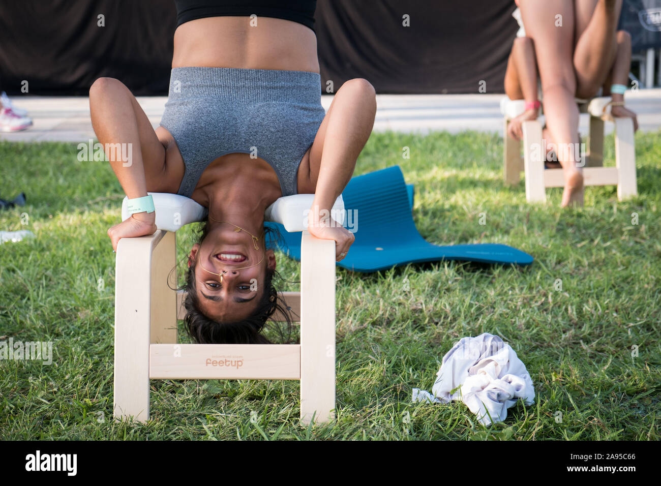 Girl in a headstand yoga stool in a yoga class at the Wanderlust festival, in Lisbon, Portugal. Stock Photo