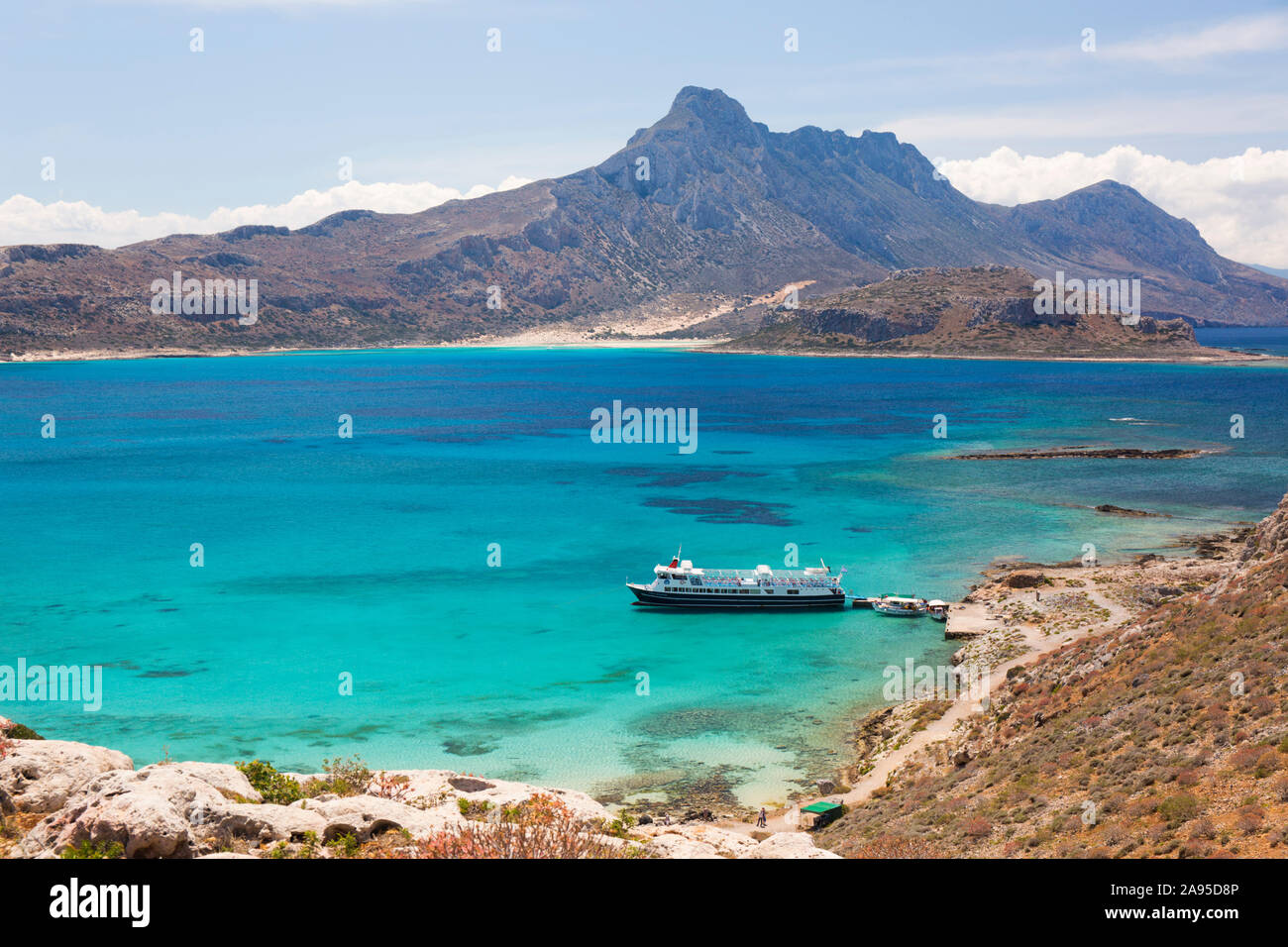 Imeri Gramvousa, Chania, Crete, Greece. View over Gramvousa Bay to Mount Geroskinos and the Gramvousa Peninsula, tour boat at jetty. Stock Photo