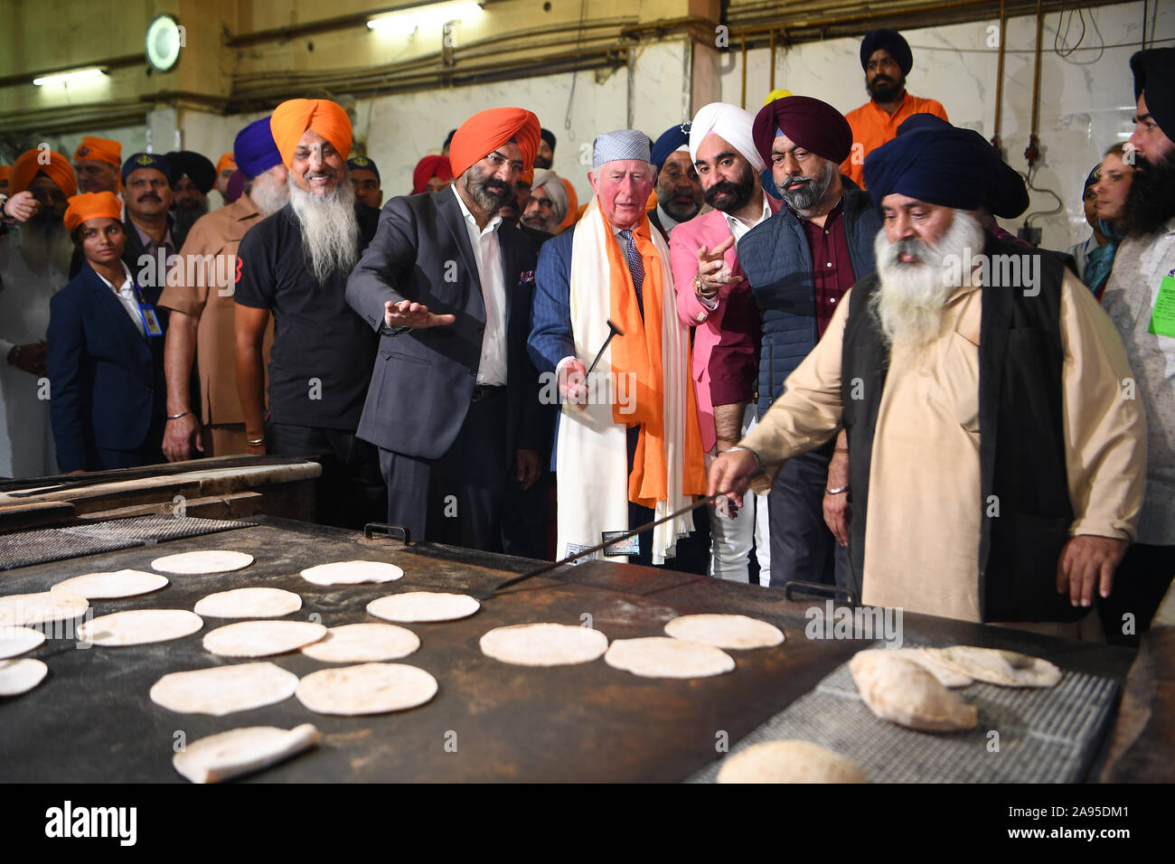 The Prince of Wales makes a chapati at the Bangla Sahib Gurdwara Sikh Temple, New Delhi, to celebrate the 550th anniversary of the birth of Guru Nanak, the founder of Sikhism, on day one of the royal visit to India. Stock Photo