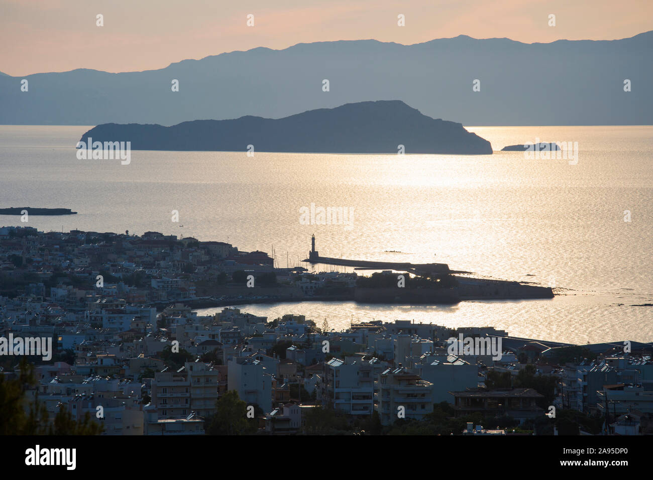 Chania, Crete, Greece. Backlit view over the city and Gulf of Chania, evening, the island of Agii Theodori prominent. Stock Photo
