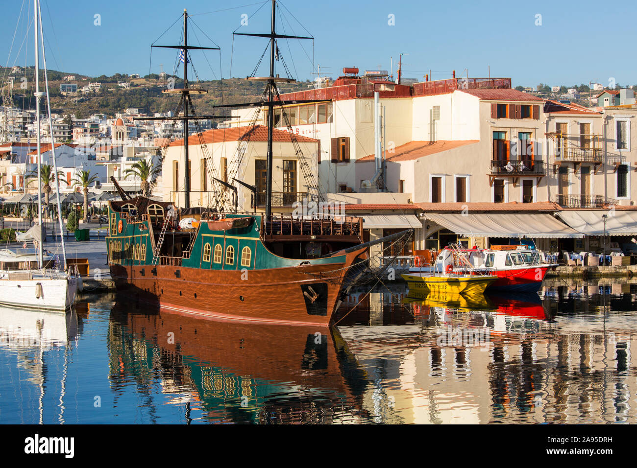 Rethymno, Crete, Greece. View across the Venetian Harbour, early morning, colourful boats reflected in still water. Stock Photo