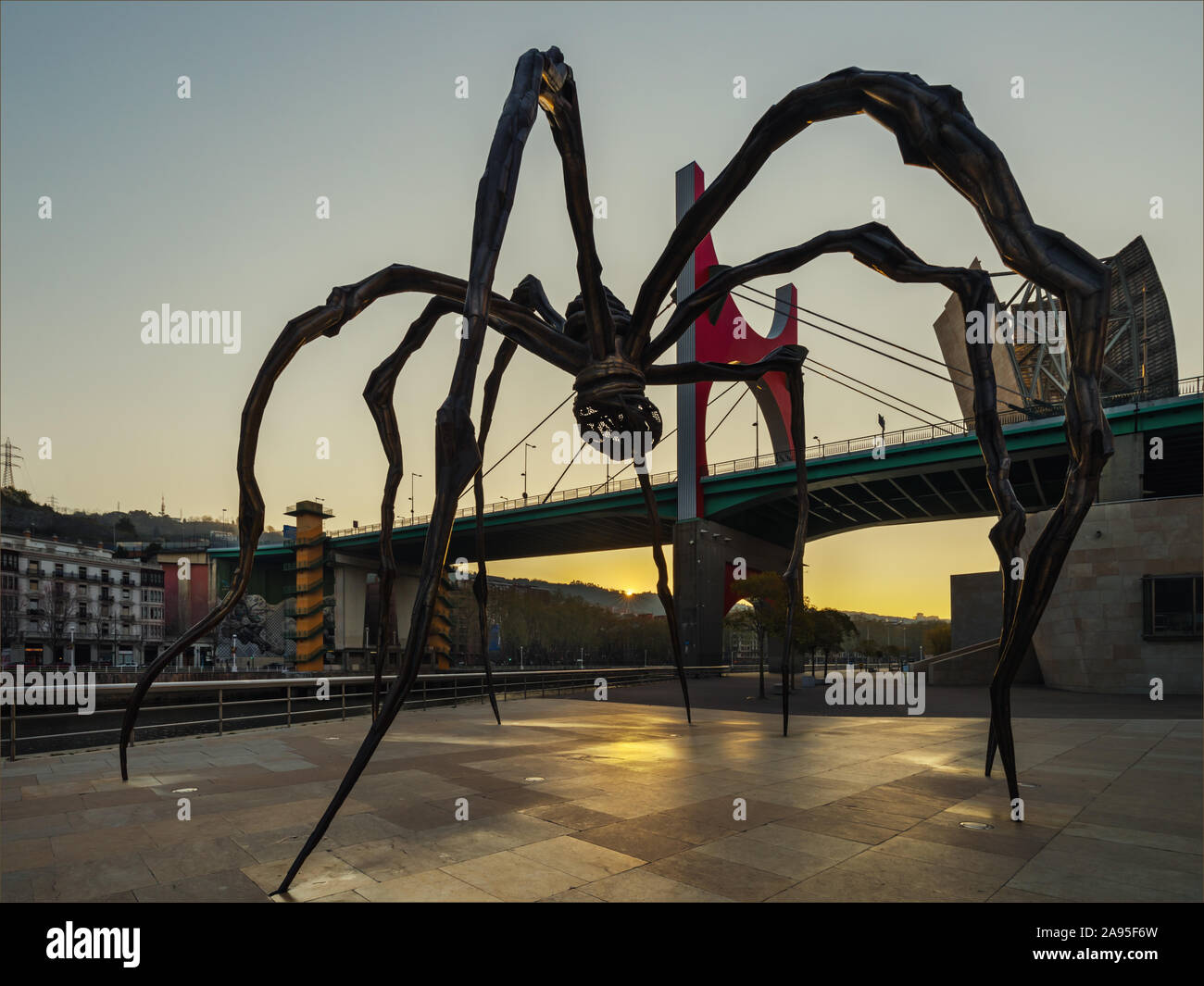 Maman spider sculpture by artist Louise Bourgeois outside the Guggenheim Museum at sunrise,  La Salve Bridge in background, Bilbao, Spain Stock Photo