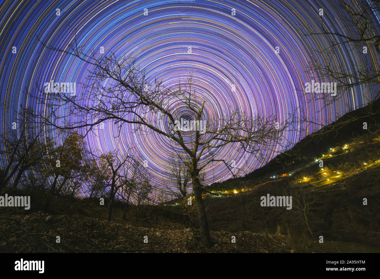 Polar star trails among the tree silhouettes that are located on Agrafa Mountains Stock Photo