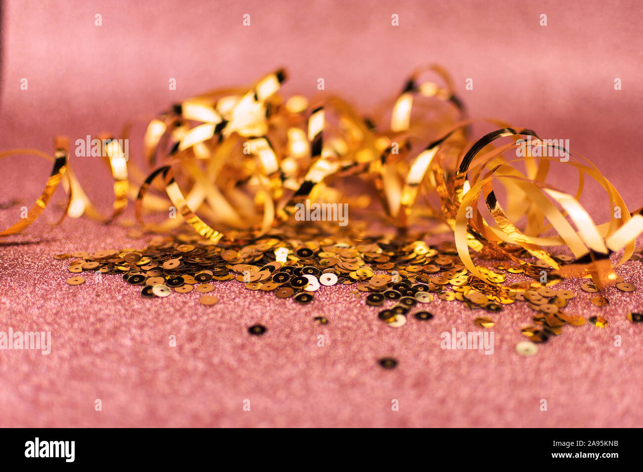 Golden sequins and metallic ribbon on glitter soft golden background. Copy space. Luxury celebration. Stock Photo