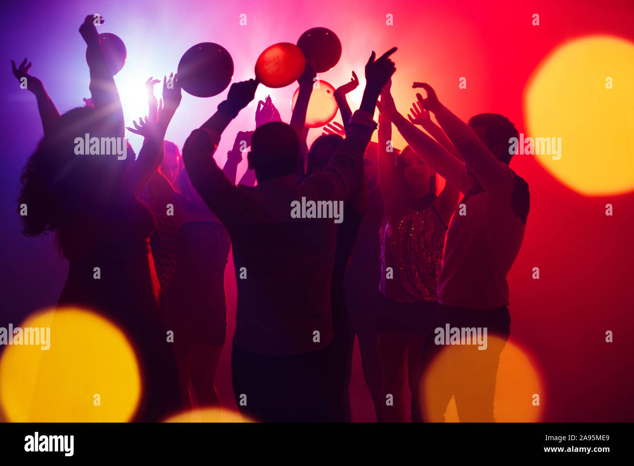 Together. A crowd of people in silhouette raises their hands on ...