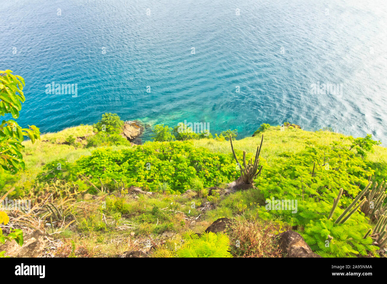 scenic green landscape gently sloping into the tranquil sea below Stock Photo