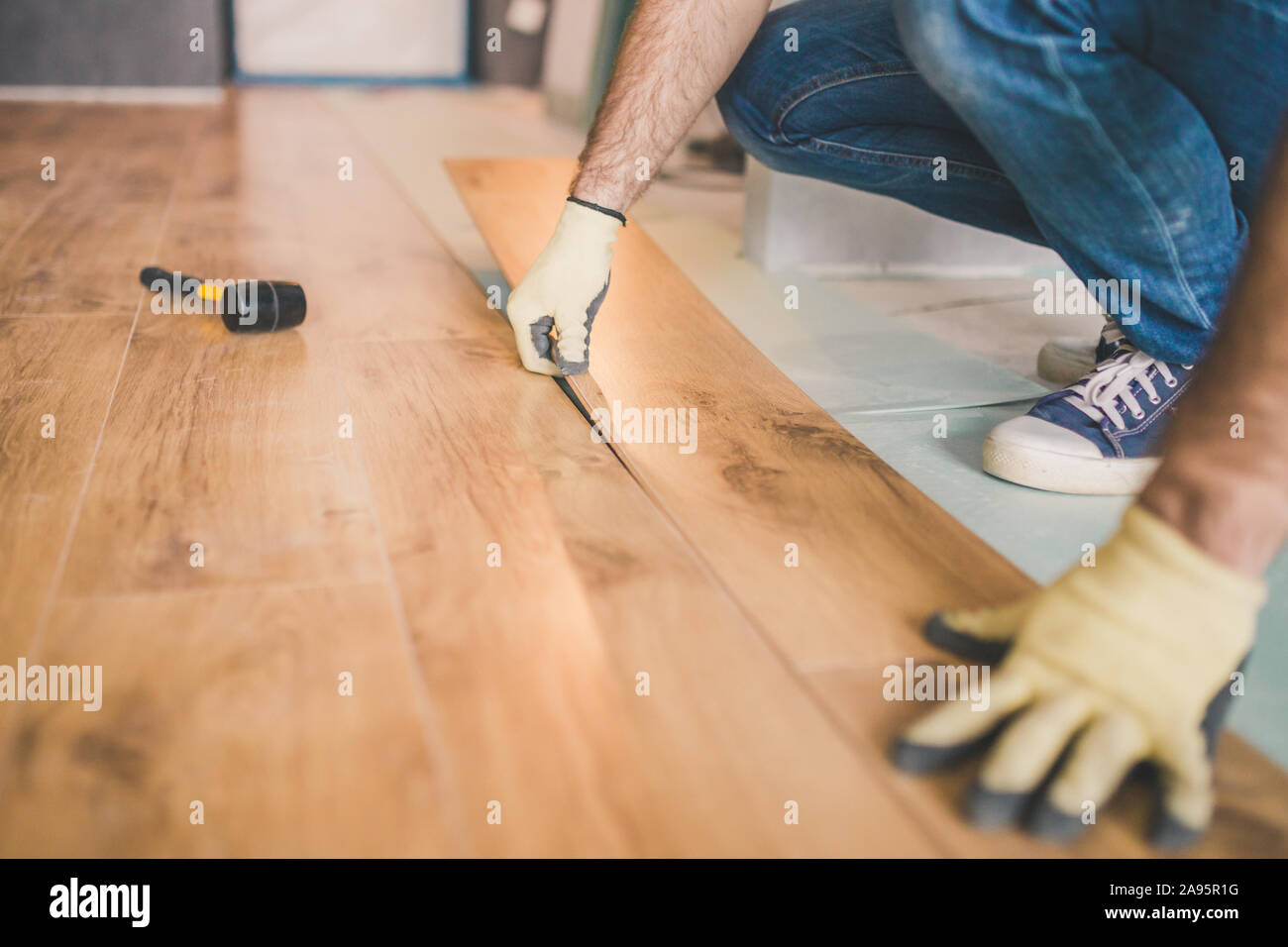 Closeup Of Master Laying Laminate Flooring In A Room Stock Photo