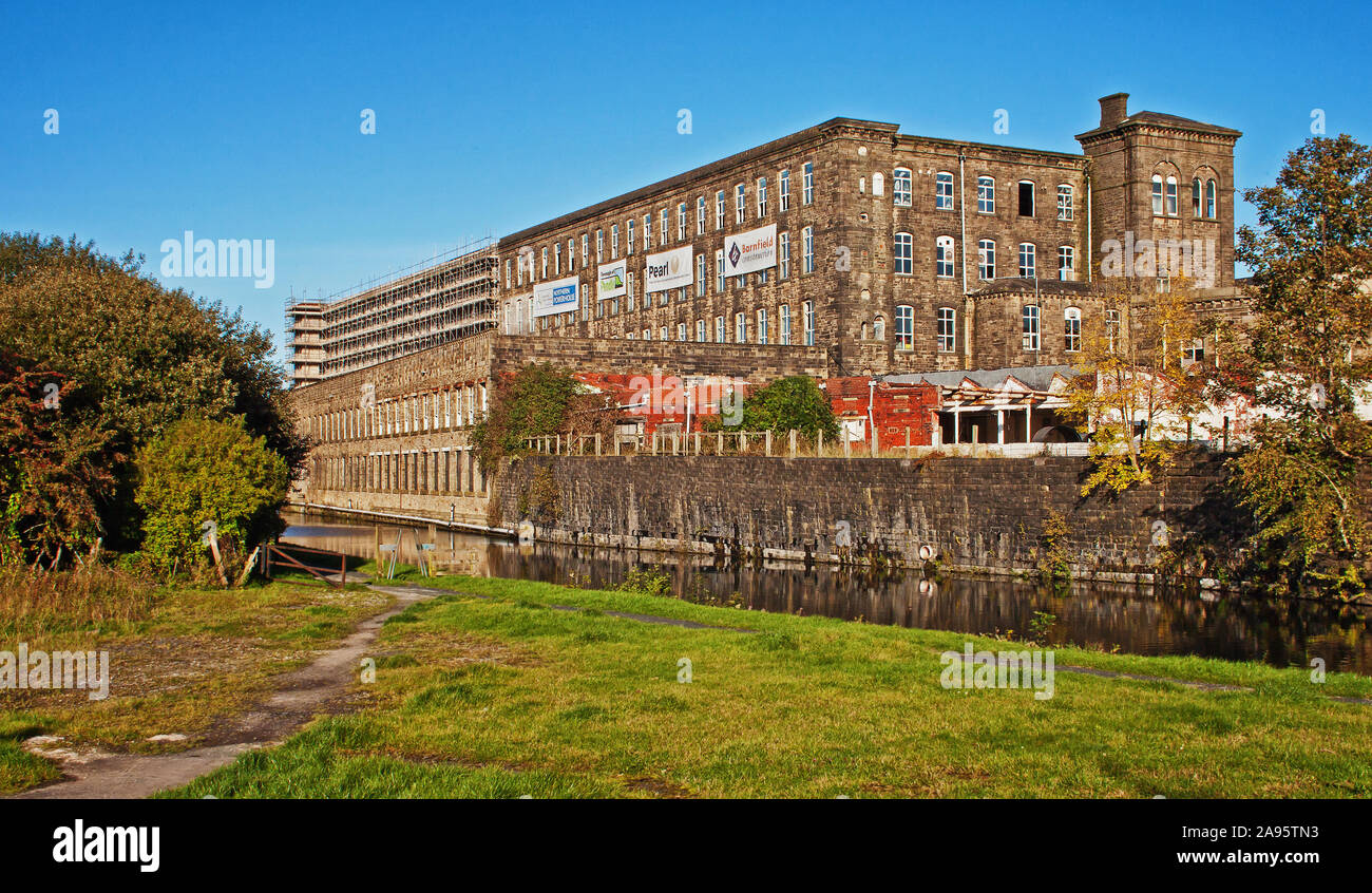 Tunstill Mill, Brierfield, by the Leeds and Liverpool Canal, under development, with scaffolding against the north section of the building Stock Photo