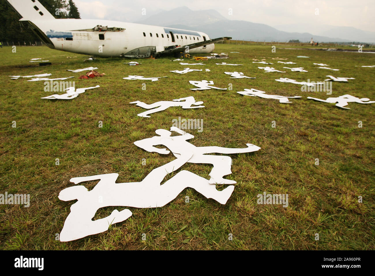 Brnik, Slovenia, October 14, 2006: Cardboard cutouts depicting victims of an air crash lie in a field during an emergency response simulation. Stock Photo