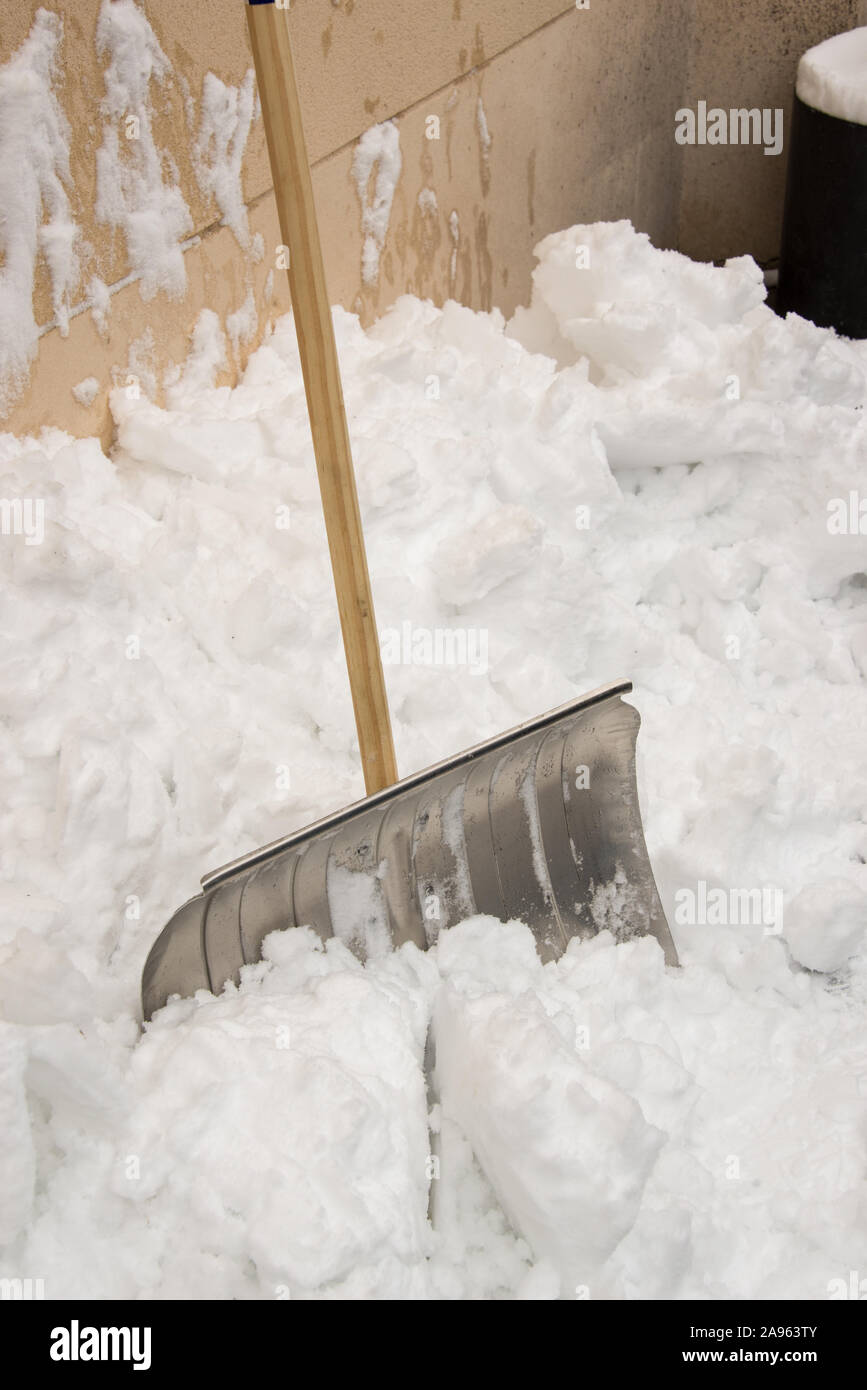 Metallic snow shovel stuck in the snow after a storm Stock Photo