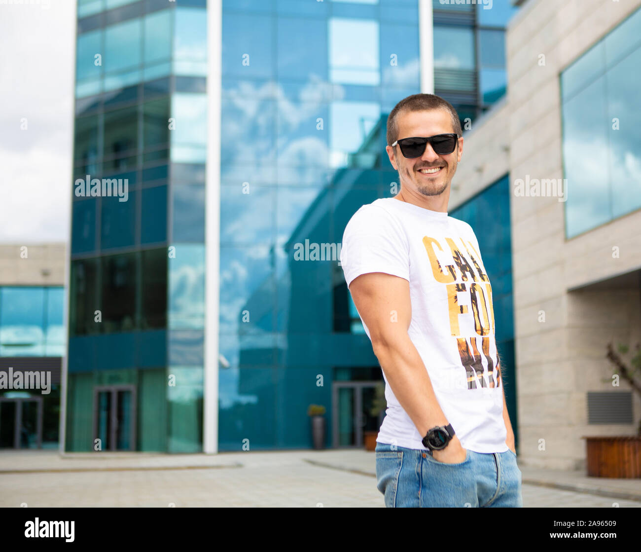Man standing outdoor near office building and smiling Stock Photo - Alamy