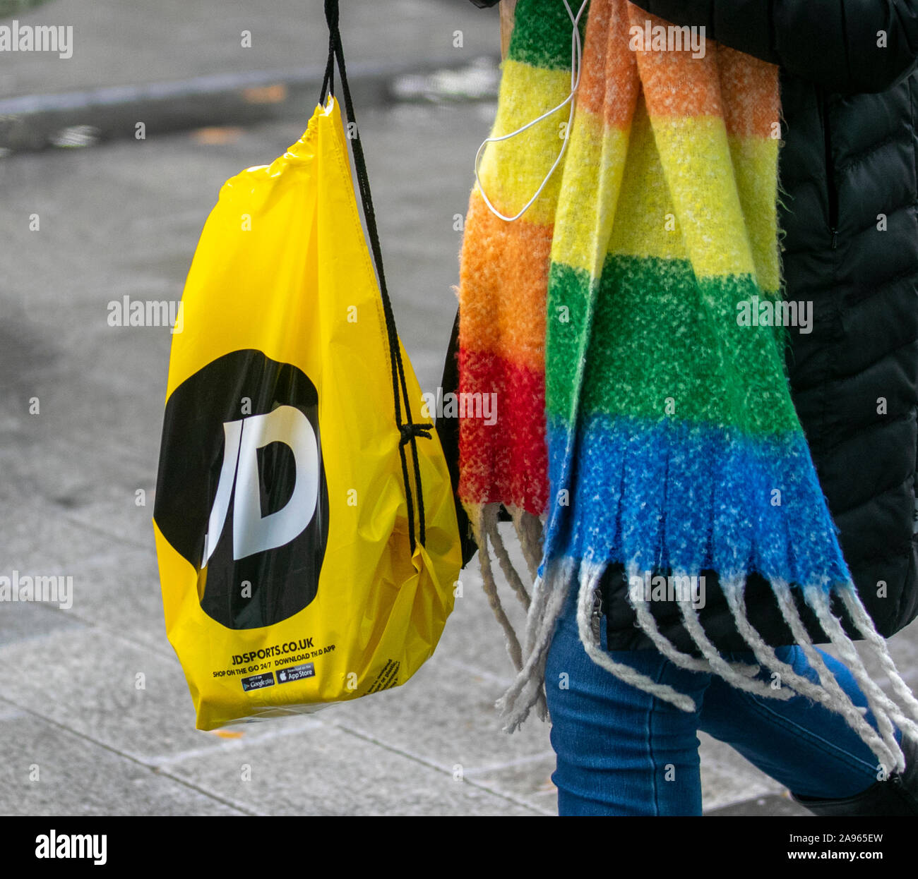 Woman carrying Yellow JD sports & LGBT Rainbow scarf; 100% recycled  reusable store Bags for Life, Chapel Street, Preston, UK Stock Photo - Alamy
