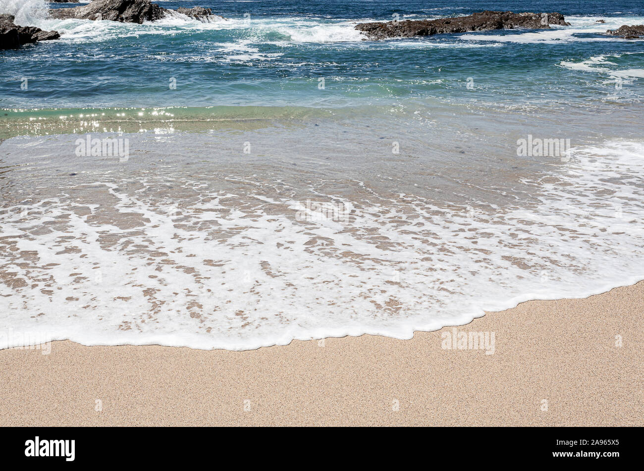 Wave with its white foam on the beach sand Stock Photo - Alamy