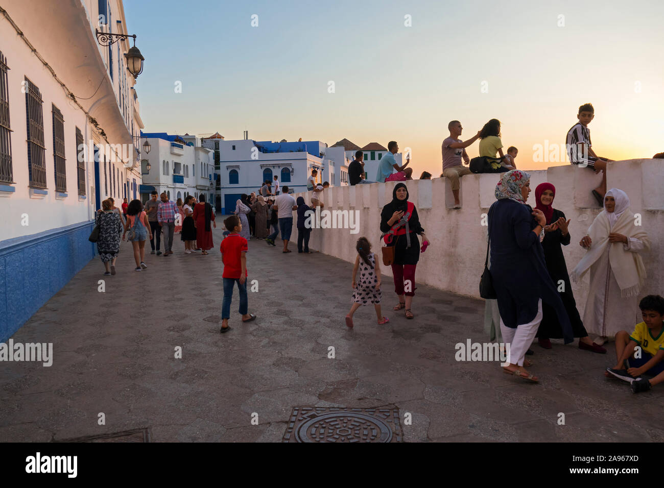 Asilah, Morocco-September 10, 2019: Tourists visiting the rampart in the medina of Asilah at twilight, Morocco Stock Photo