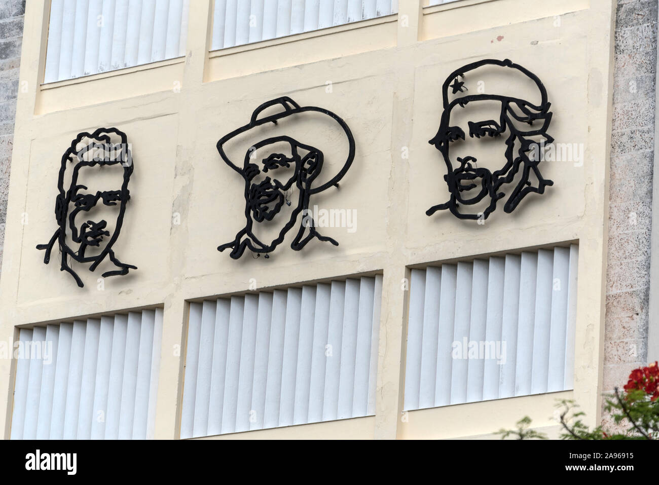 The three stylized portraits of three were heroes of the Cuban Revolution, Julio Antonio Mella, Camilo Cienfuegos and Che Guevara, high up on the wall Stock Photo