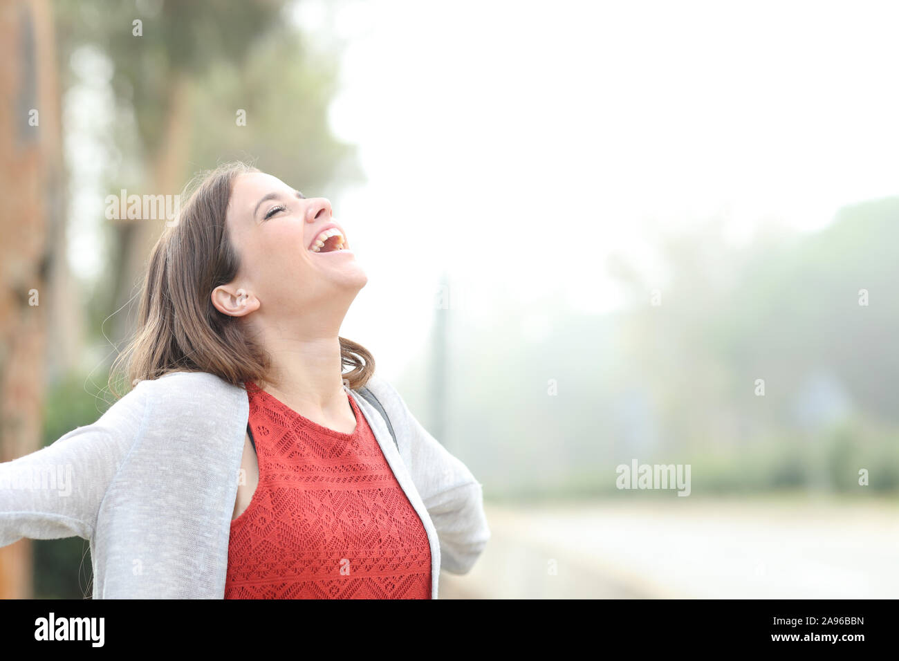Happy woman breathing fresh air standing in a park a foggy day Stock ...
