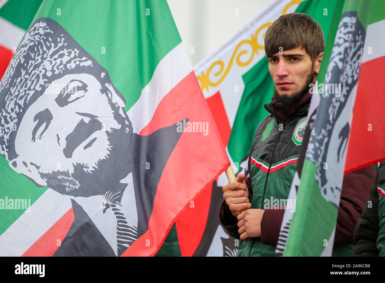 russia-13th-nov-2019-chechen-republic-russia-november-13-2019-a-young-man-holds-a-chechen-flag-bearing-a-likeness-of-late-chechen-leader-akhmad-kadyrov-at-the-inauguration-ceremony-for-a-newly-built-section-of-the-r-217-motorway-and-a-bridge-across-the-aksai-river-on-the-border-between-chechnya-and-dagestan-in-russias-north-caucasus-the-r-217-motorway-links-the-city-of-krasnodar-to-grozny-and-makhachkala-and-connects-south-west-russia-to-azerbaijan-yelena-afoninatass-credit-itar-tass-news-agencyalamy-live-news-2A96CB8.jpg