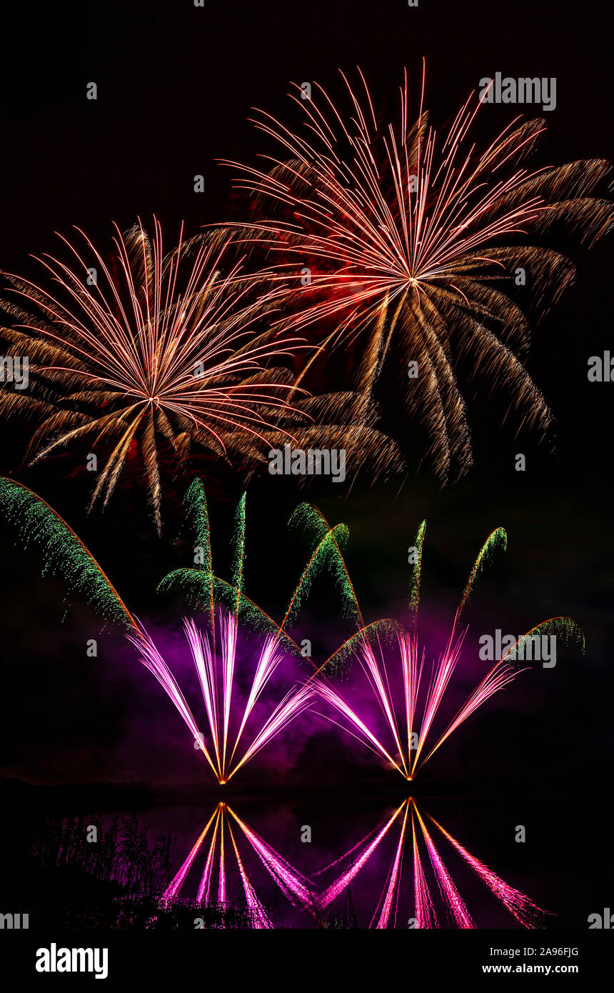 Firework display over water. Stock Photo