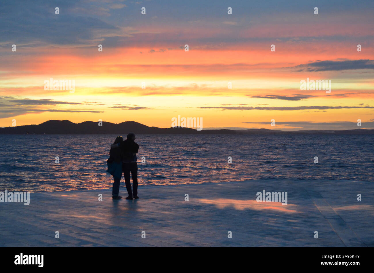 Incredible sunset (sunrise, dawn) at sea with silhouettes of people (couple) in Zadar (Croatia) Stock Photo