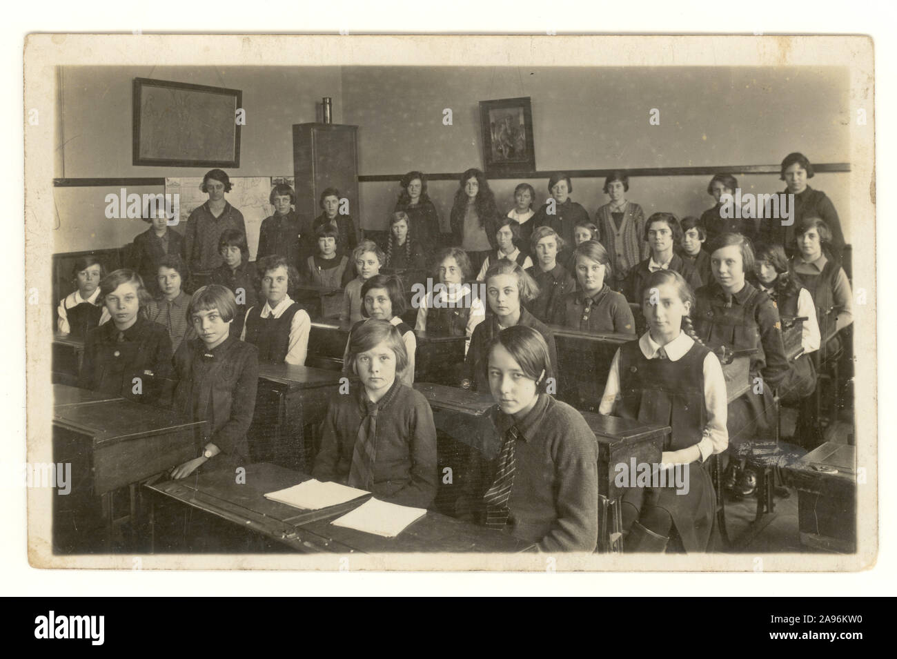 Early 1900's, WW2 era postcard of junior schoolgirls in their school room, circa 1930's, U.K. Stock Photo