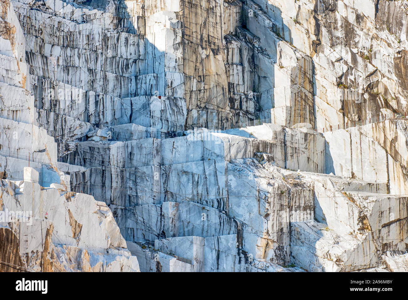 Detail of an Italian Marble quarry or open cast mine pit showing the rock face where the stone is excavated in blocks for construction and sculpture i Stock Photo