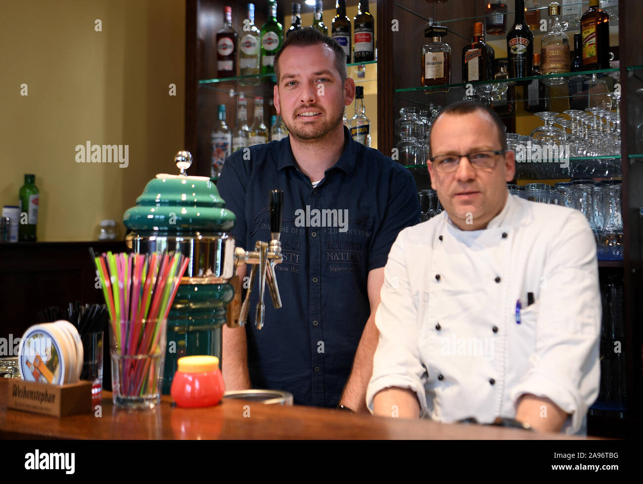 13 November 2019, Brandenburg, Grünheide: Host Holger Haustein (l) from the Grünheider restaurant 'Heydewirt' and his business partner and cook Carsten Goretzki are standing behind the counter in their restaurant. The restaurateur is pleased about the plans of the electric car manufacturer Tesla to build a new factory for electric cars in the Brandenburg community of Grünheide. Photo: Monika Skolimowska/dpa-Zentralbild/dpa Stock Photo